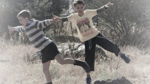 2 jongens balanceren op een steen